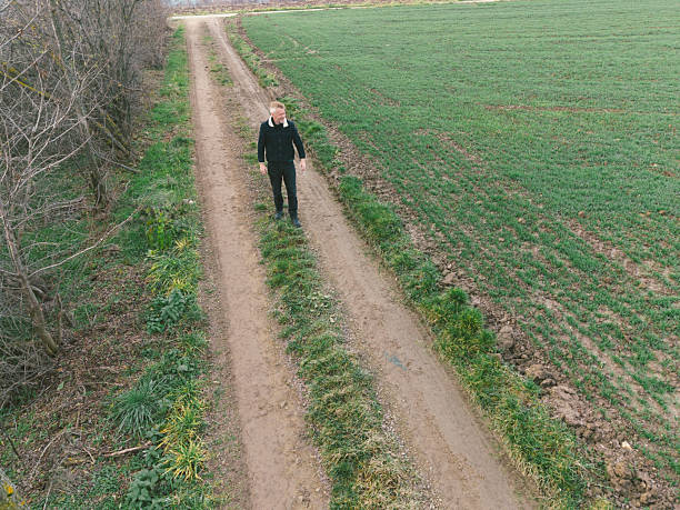 Farmer looking at his agricultural fields in winter morning