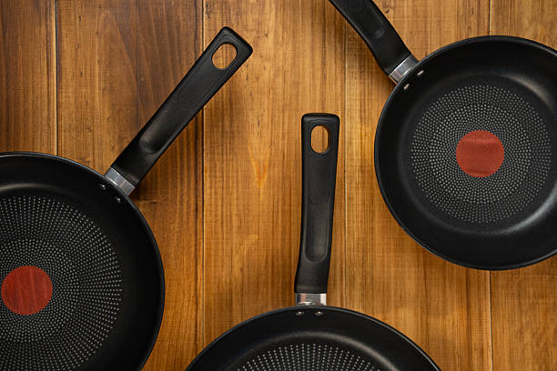 istock Nonstick frying pans resting on a dark rustic wooden background with space for copy. Kitchen cooking theme 2252744323