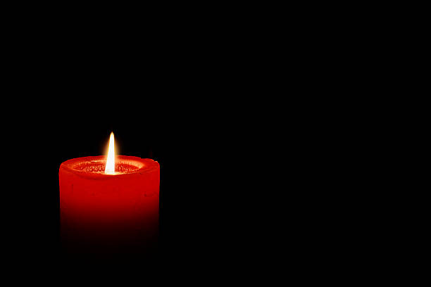 Red candles glowing in the darkness creating a warm dramatic atmosphere, symbolizing hope spirituality romance and meditation for artistic and commercial use