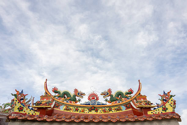 A vibrant display of traditional Chinese dragon sculptures adorning a temple roof, showcasing intricate craftsmanship against a serene sky backdrop. The scene captures cultural heritage and architectural beauty, ideal for cultural studies or travel imagery.