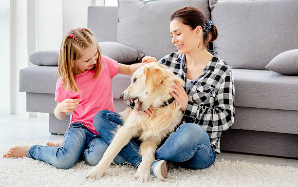 istock Mother and daughter playing with dog 2252750386