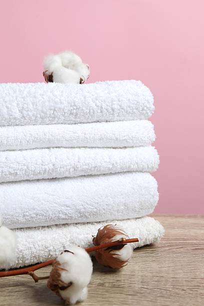 istock Stack of bath towels with cotton flowers on the table 2252752001