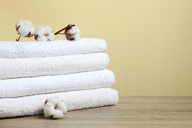 istock Stack of bath towels with cotton flowers on the table 2252752030