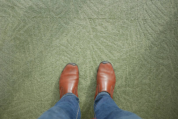 istock Brown shoes on green carpet while standing indoors 2252757978