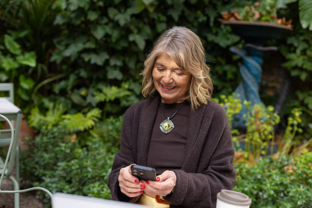 istock Senior woman smiling connecting using modern phone technology 2252758070
