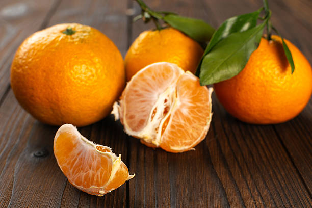 istock Fresh Tangerines with Leaves on Rustic Wooden Table 2252758315