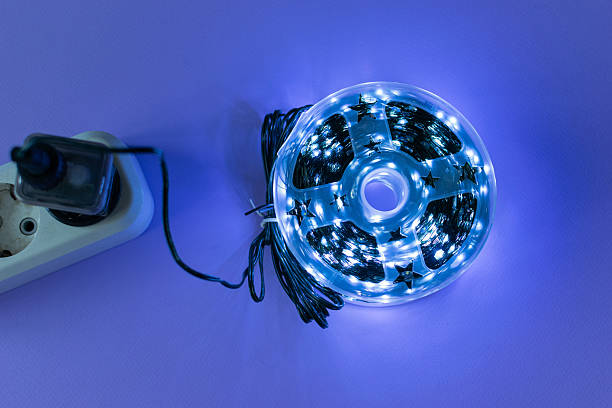 istock Glowing LED Light Strip with Reflection on Purple Background and Plug Adapter 2252758326