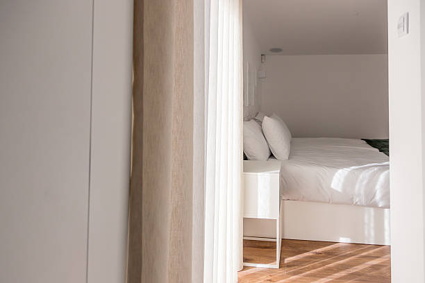 istock Soft daylight filters through curtains into a cozy bedroom with a neatly made double bed, white linens and pillows, creating a calm, inviting space for rest and relaxation in a modern home. 2252761101