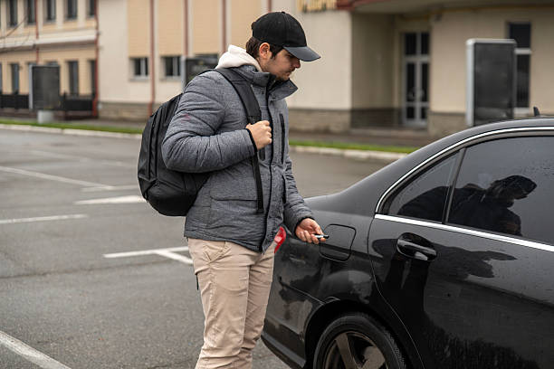 istock Young man opening black car on parking lot 2252761131