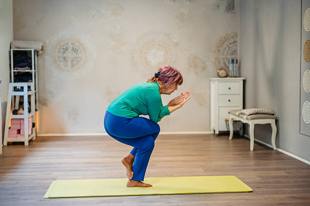 istock Senior Woman Doing The Eagle Pose In A Yoga Studio Indoors 2252761943