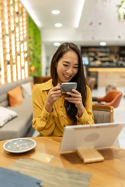 istock Woman enjoying coffee browsing tablet in cafe 2252762038