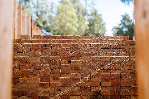 A front view of a large stacked pile of 2x4 beams, ready to aid in the framing of a new home build.  Valuable natural wood materials.