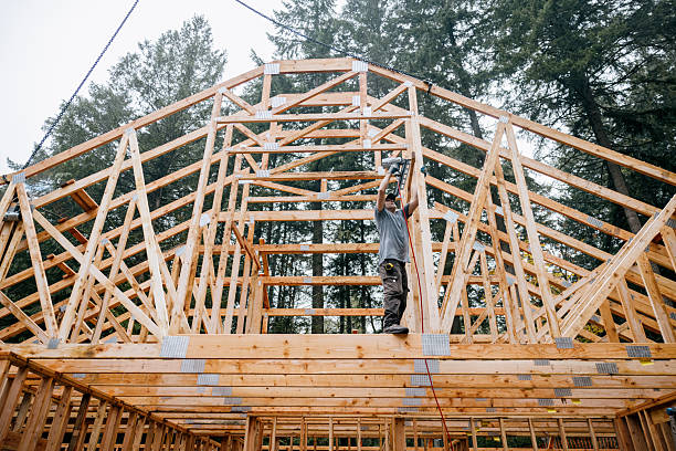 Detailed view of a wooden truss roof structure under construction, featuring light through translucent panels and unfinished concrete block walls below.