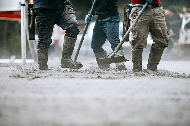 Men Work Pouring Concrete Slab At Home Build