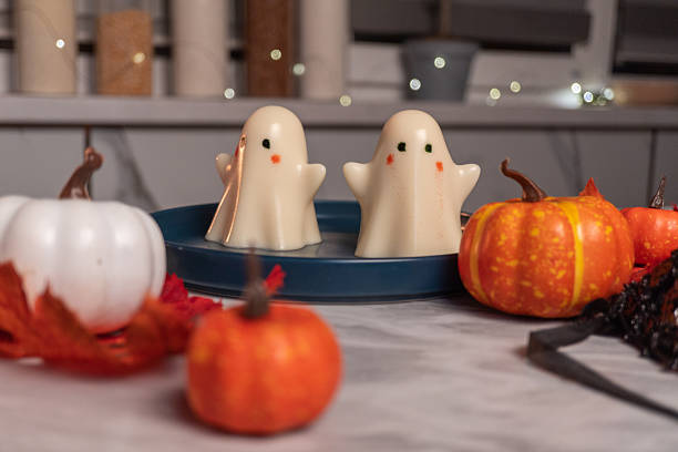 Festive halloween decor with ghost candles and pumpkins in cozy indoor setting