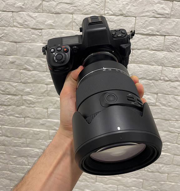 istock A person grips a camera with a sizable lens, showcasing the gear against a light surface 2252772695