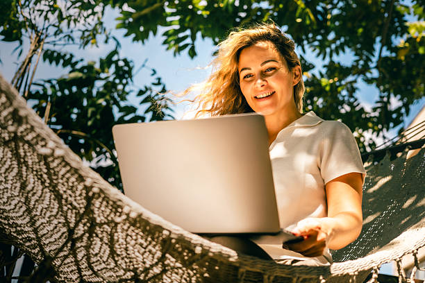 istock Woman using laptop in hammock outdoors on sunny day with natural light and relaxed mood 2252774312