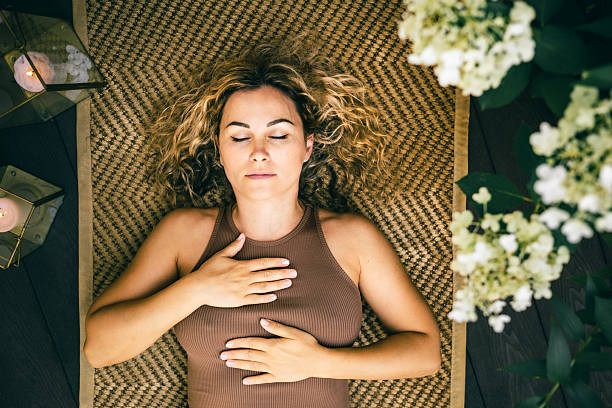 istock Woman practicing deep relaxation and mindfulness while lying on mat with eyes closed 2252774455