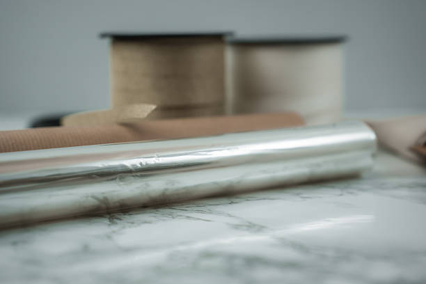 Crafting unique gift wraps using shiny paper, ribbons, and various materials to prepare presents for holiday celebrations. The scene captures the joy of Christmas wrapping