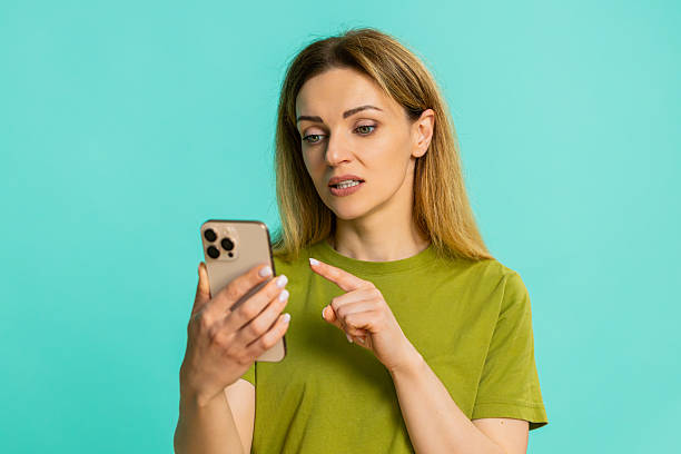 istock Young woman sadly looking at smartphone sighing deeply waiting for message that never comes appears 2252775661