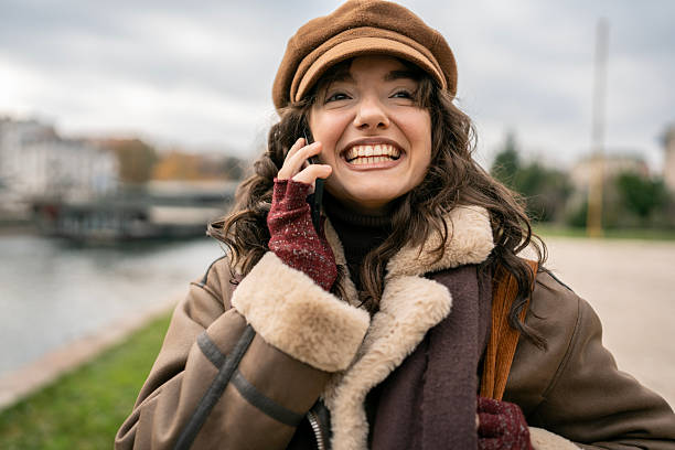 istock Joyful Woman in Brown Shearling Coat Talking on Phone Outdoors on Cold Day 2252777682