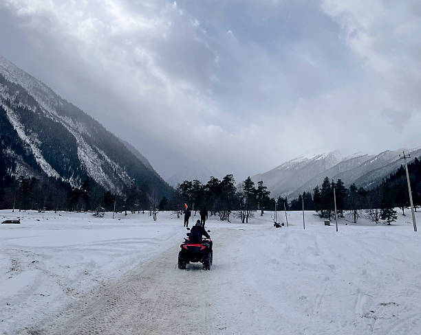 istock Riders explore a snowy path in the mountains during a cloudy winter day 2252782499