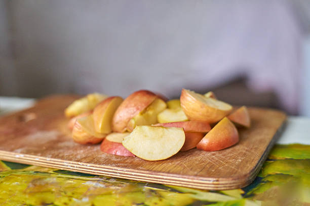 Mans hands slicing fresh apples on a cutting board, topdown view. Healthy eating concept. Use for blogs, recipes, wellness articles, or foodrelated websites.