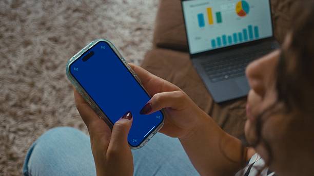 istock Woman on sofa looking at cell phone with blue screen - 4k video 2252791885