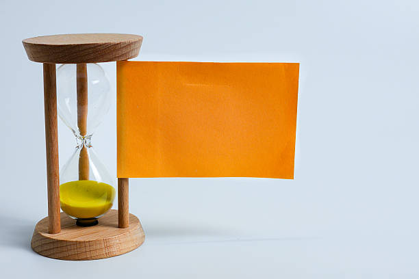 Hourglasses and a blank sticky note for custom text on a white background, representing the concept of self-care and mindfulness.