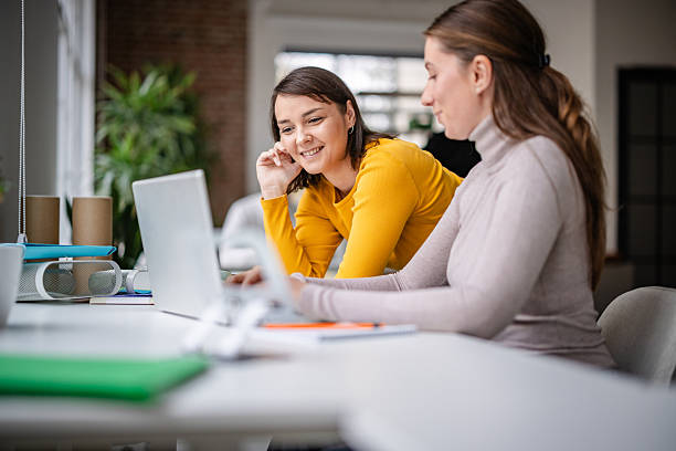 istock Adults work together in an office setting, engaging with technology and sharing ideas during a busy workday 2252796589