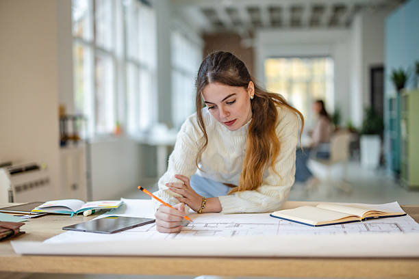 istock Office scene with adult working on project plans with documents and technology during daytime 2252799145