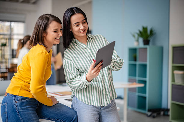istock Two adults engage with a tablet in a modern office space during work hours 2252801481