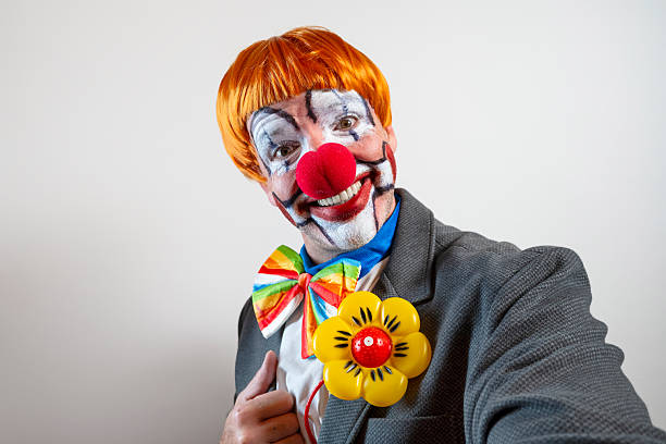 A close up of the face of a vintage creepy-looking clown doll.