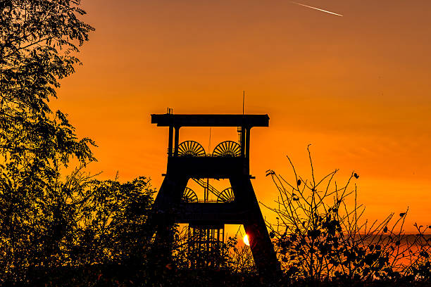 The sky burns with copper and gold, as if the day had decided to say goodbye solemnly. The old conveyor stands still, an iron guardian between the past and the evening light. Here the air smells of stories, of work, of time that does not hurry. The sun squeezes its way through steel and struts one last time and whispers: Even industry can dream.