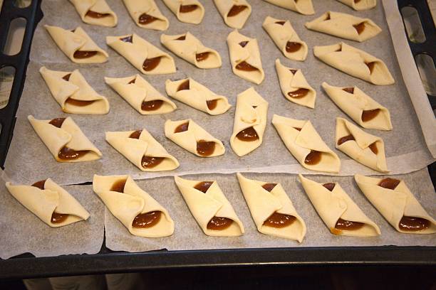 istock Raw Puff Pastry Slippers Filled with Apricot Jam on Baking Paper 2252815916