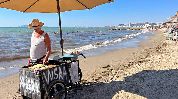 Golem beach, Kavajë, Albania - Aug 25, 2025: Vendor selling grilled corn on the Golem beach