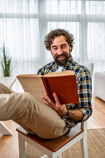 istock Content man enjoying reading book at home 2252817931