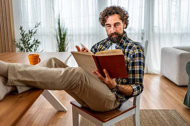 istock Man reading book relaxing at home, enjoying leisure time 2252818297