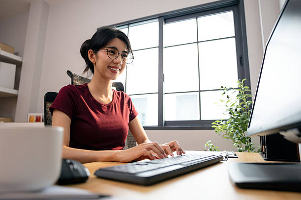 istock Happy Asian woman typing on keyboard while working from home in bright modern office, reflecting productivity, remote work, and digital lifestyle with positive energy 2252820008