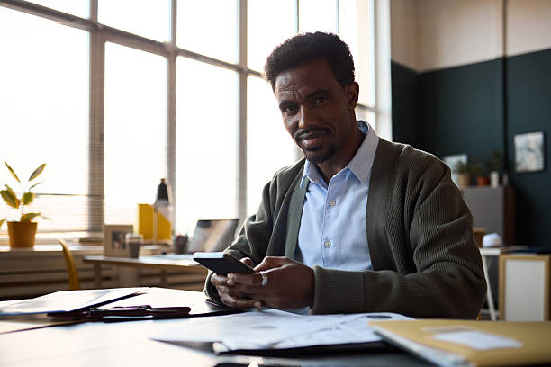 istock Portrait of Black Man Using Smartphone While Working in Office 2252821674