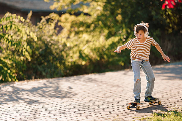 istock Boy enjoying music while skateboarding outdoors in sun. 2252822452