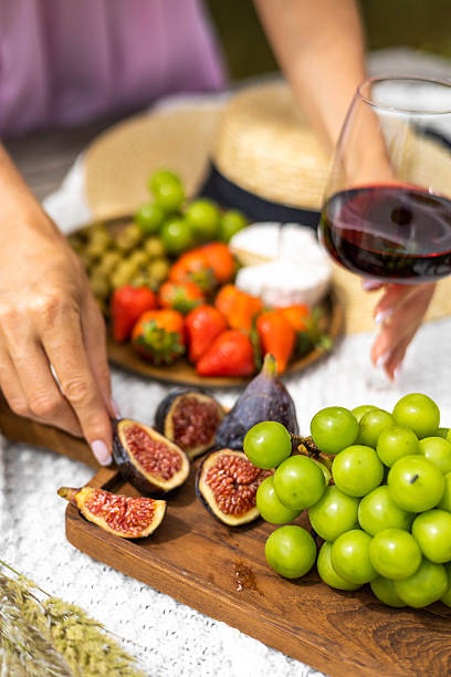 istock Fresh figs, grapes, strawberries, and red wine on a summer picnic boar 2252822935