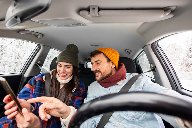 istock Couple using smart phone gps while travelling to winter vacation by car 2252823783