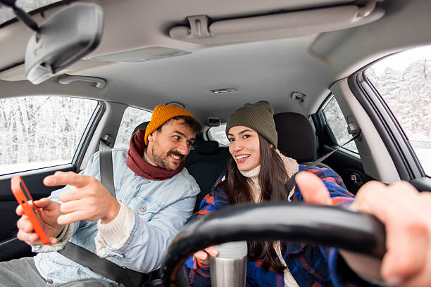 istock Couple using smart phone gps while travelling to winter vacation by car 2252823803
