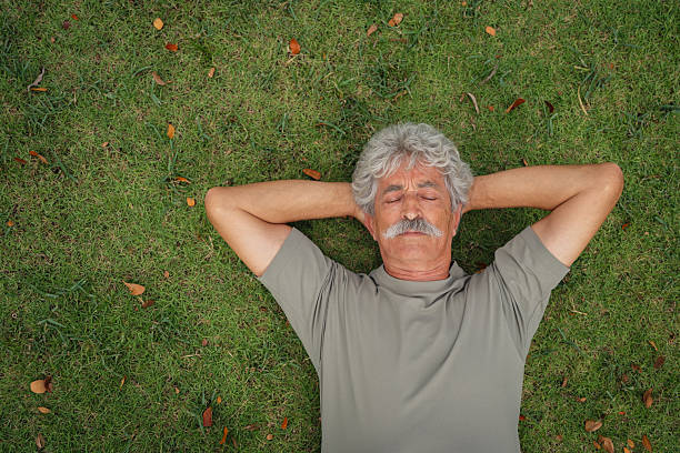 istock Senior man relaxing outdoors on the grass 2252823942