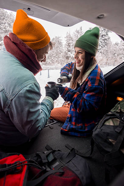 istock Couple taking a break while going for weekend vacation road trip, drinking hot tea in a car trunk 2252824181
