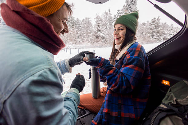 istock Couple taking a break while going for weekend vacation road trip, drinking hot tea in a car trunk 2252824351