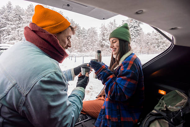 istock Couple taking a break while going for weekend vacation road trip, drinking hot tea in a car trunk 2252824400