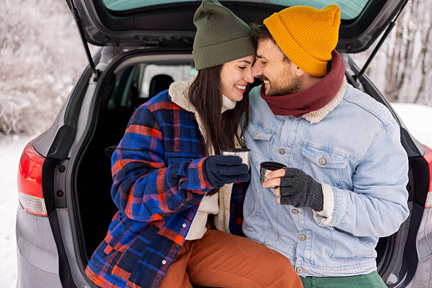 istock Couple taking a break while going for weekend vacation road trip, drinking hot tea in a car trunk 2252824479