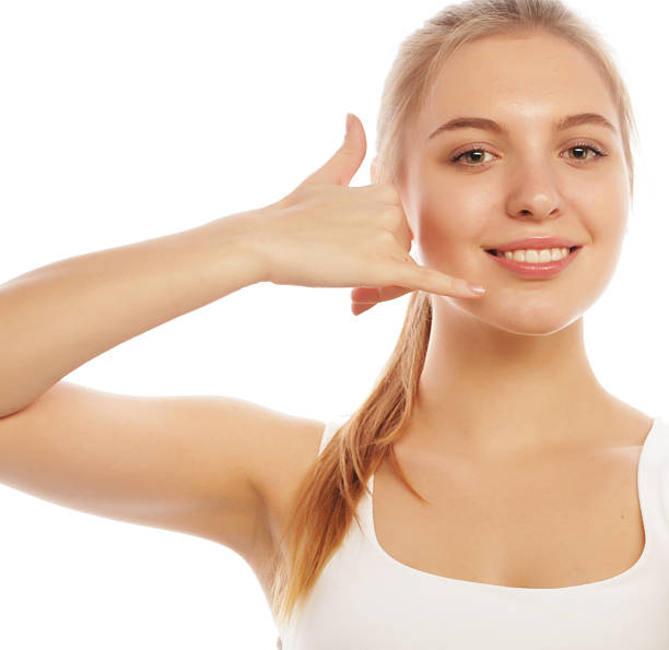 istock beautiful young woman making a call me gesture 2252829893